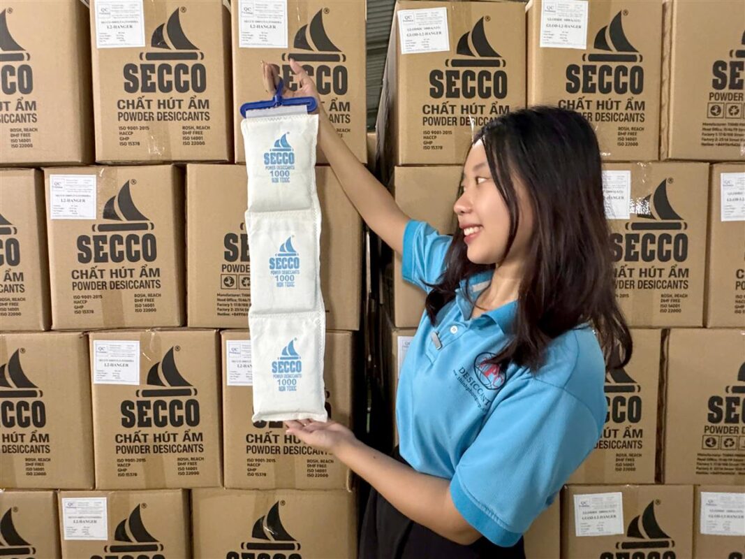 Nhân viên SECCO cầm dây treo hút ẩm container trước kho hàng